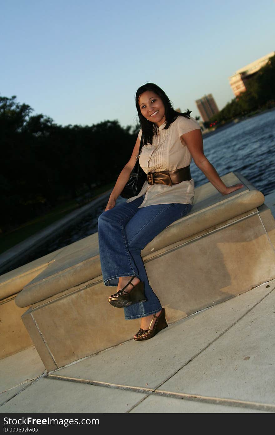 Pretty girl carrying a purse enjoying sunset at park with sunset ray shine over her face. Pretty girl carrying a purse enjoying sunset at park with sunset ray shine over her face