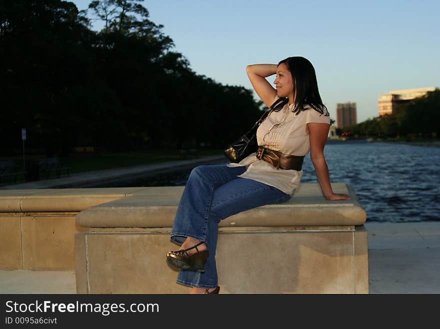 Pretty girl carrying a purse enjoying sunset at park with sunset ray shine over her face. Pretty girl carrying a purse enjoying sunset at park with sunset ray shine over her face