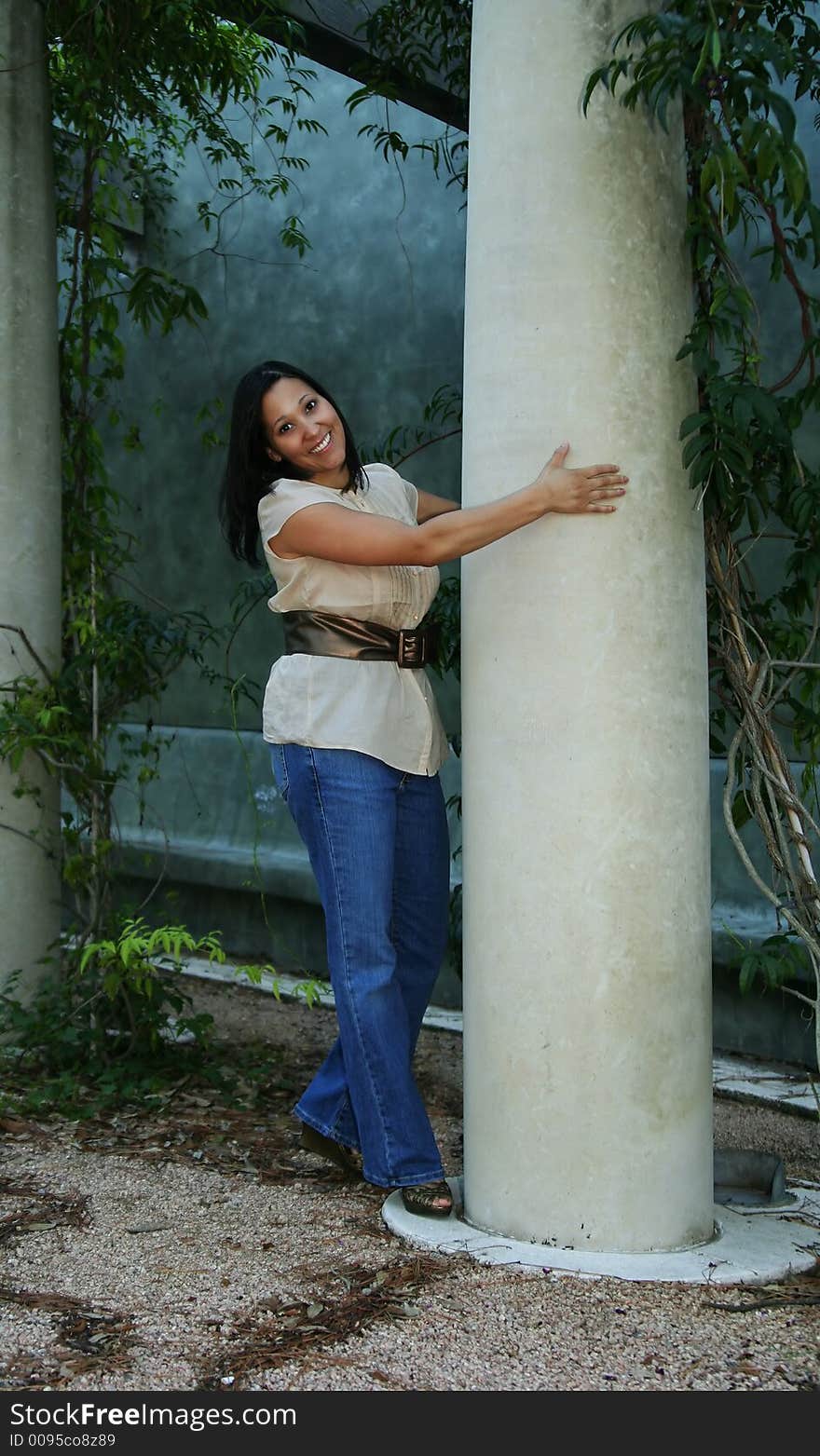 Girl holding pillar with a happy face. Girl holding pillar with a happy face