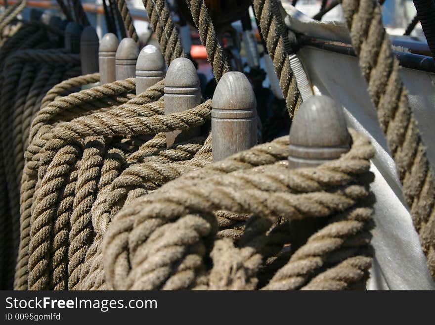 Row of ropes tied around wooden cleats (focus on the middle) photographen on a tall ship