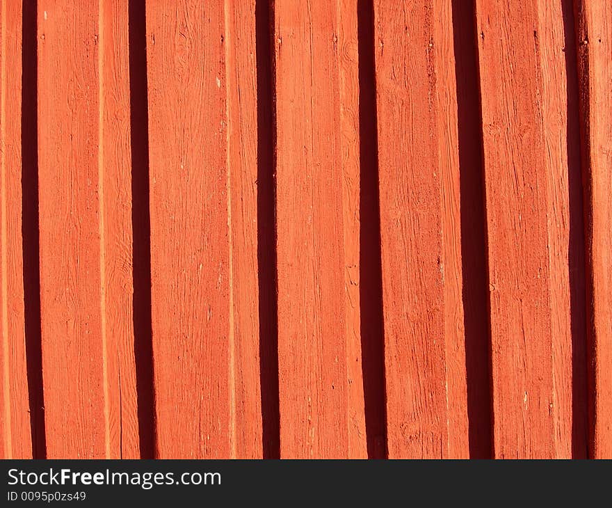 Red painted wall made of planks.