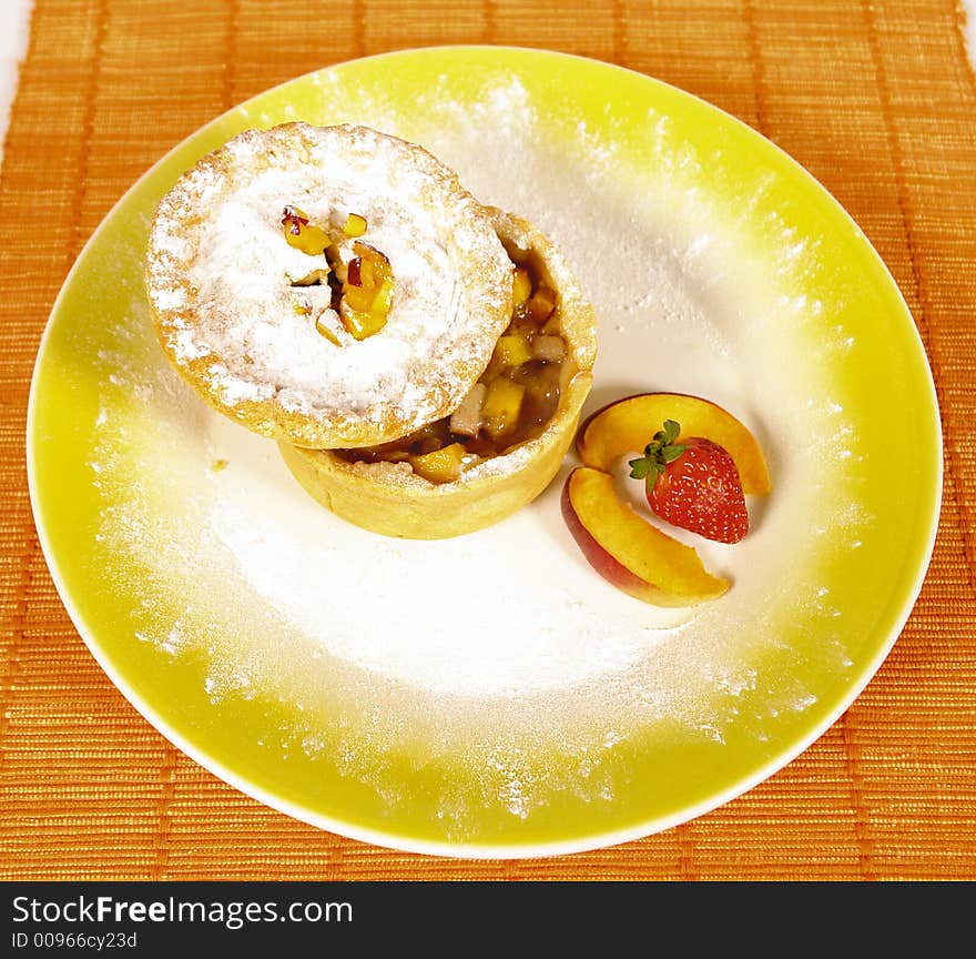 Homemade apple pie with powdered sugar and peach and strawberry decoration