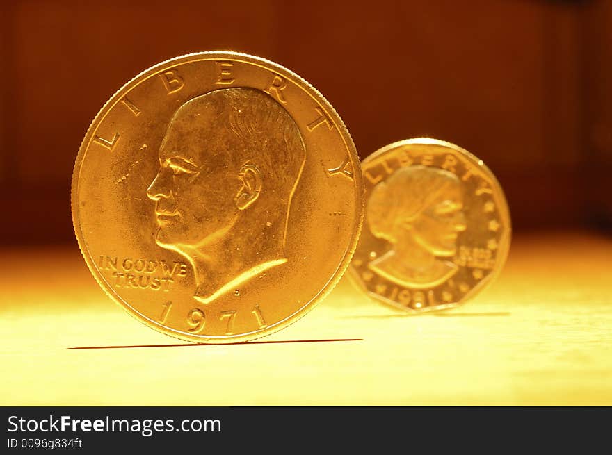 Some golden coins in a yellow light. Some golden coins in a yellow light.