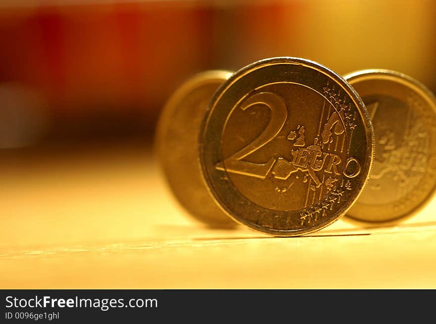 Some golden coins in a yellow light. Some golden coins in a yellow light.