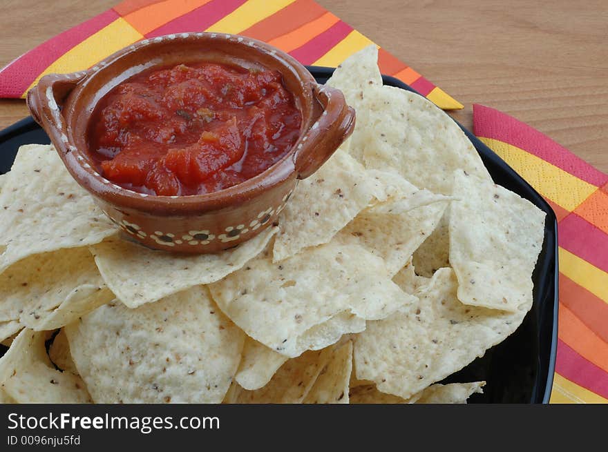 Bowl of salsa atop a plate of tortillas. Bowl of salsa atop a plate of tortillas