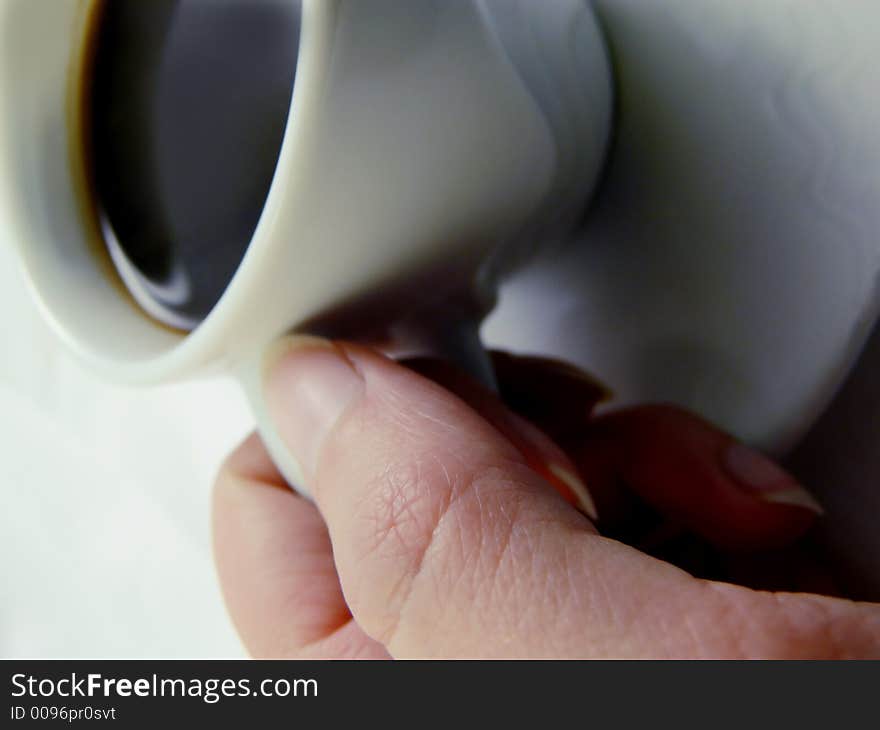 A cup of black coffee kept by a woman