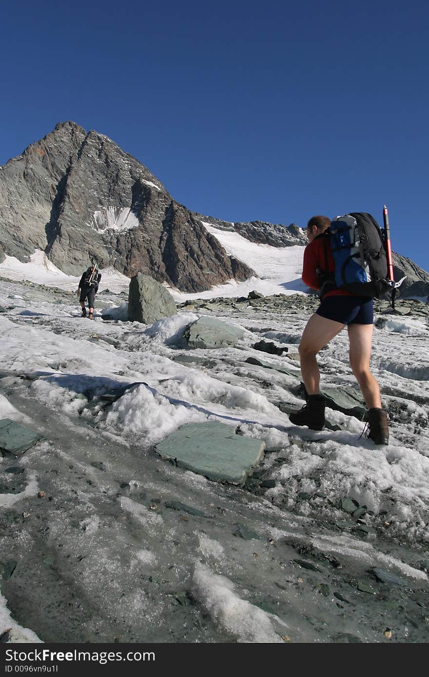 Climber with heavy backpack walking on glacier. Climber with heavy backpack walking on glacier