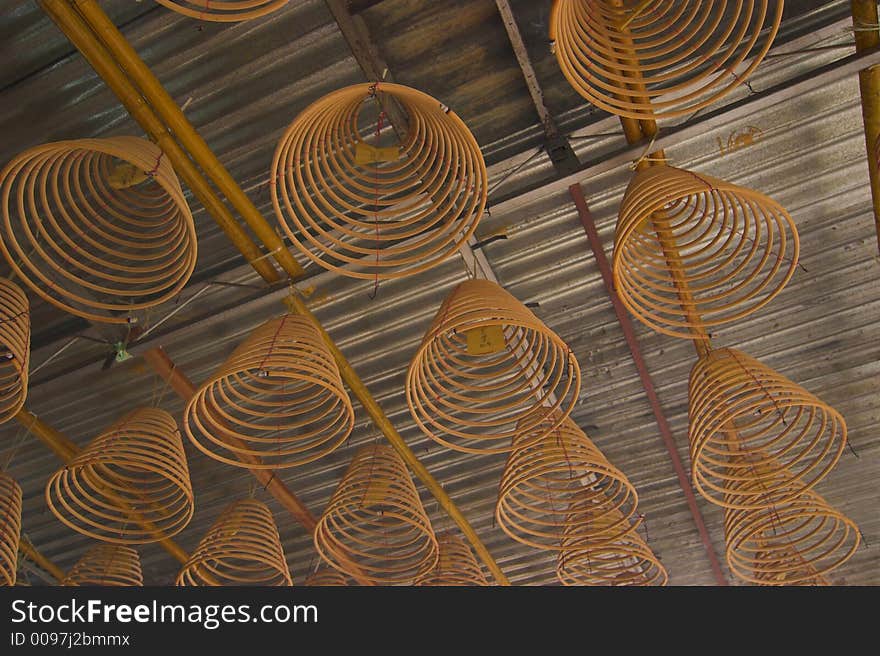 Hanging circular joss-sticks against dark background. Hanging circular joss-sticks against dark background