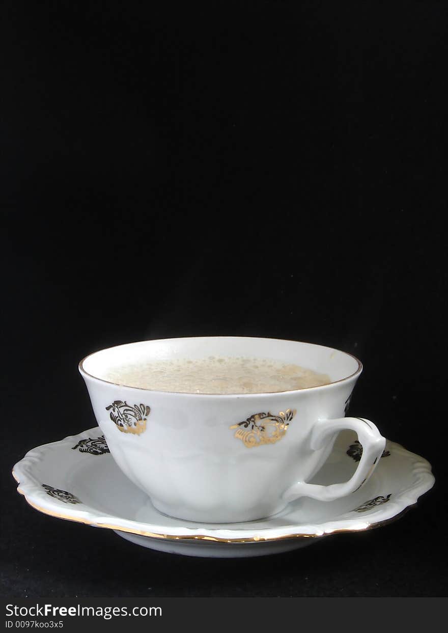 Porcelain cup of cappuccino on black background