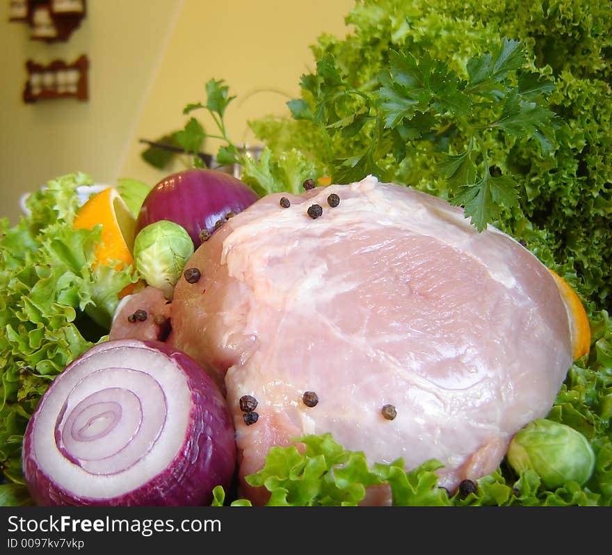 Fresh pork meat garnished with lettuce, purple onion, orange slice, apple and parsley. Fresh pork meat garnished with lettuce, purple onion, orange slice, apple and parsley