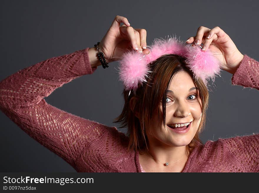 Brunette model with alien antenna in front of grey background