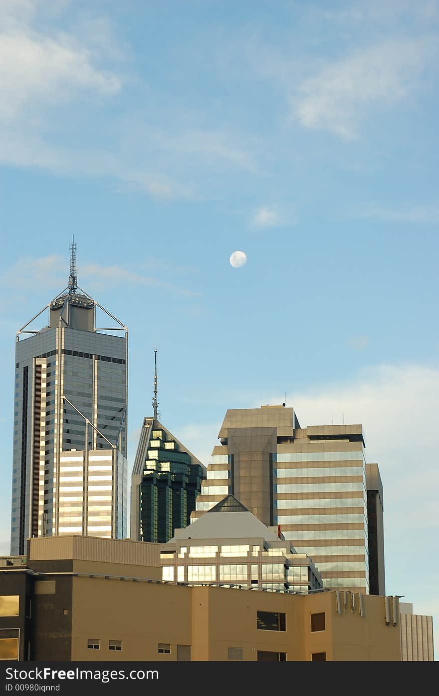 Moon over Perth skyscrapers as sun lights their windows. Moon over Perth skyscrapers as sun lights their windows