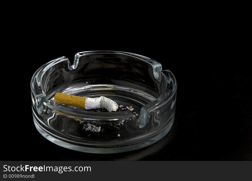 Cigarette in ashtray isolated on black background