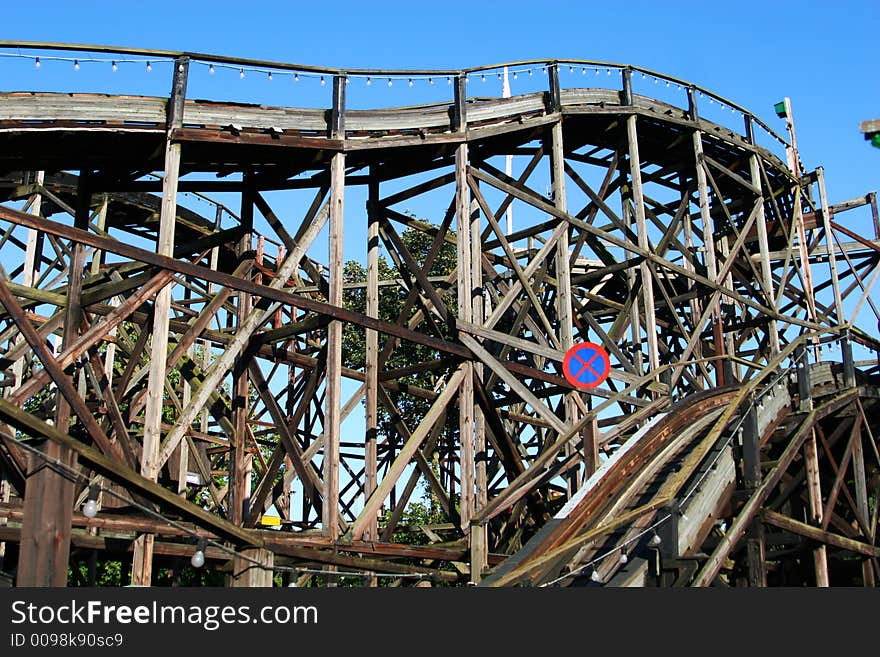 A very old wooden rollercoaster track, bright blue sky in background. A very old wooden rollercoaster track, bright blue sky in background