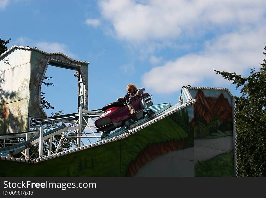 A small boy riding in a rollercoaster having loads of fun. A small boy riding in a rollercoaster having loads of fun