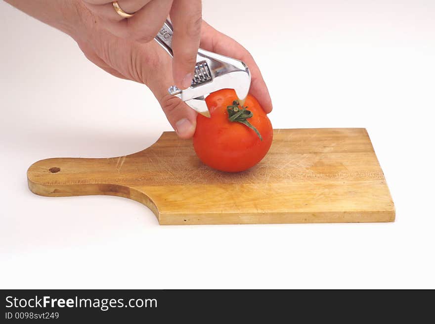 a tomato on a wooden plate. a tomato on a wooden plate