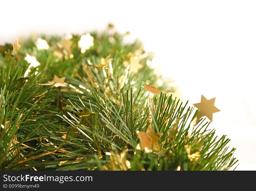 Close-up of green christmas garland with gold stars isolated on white