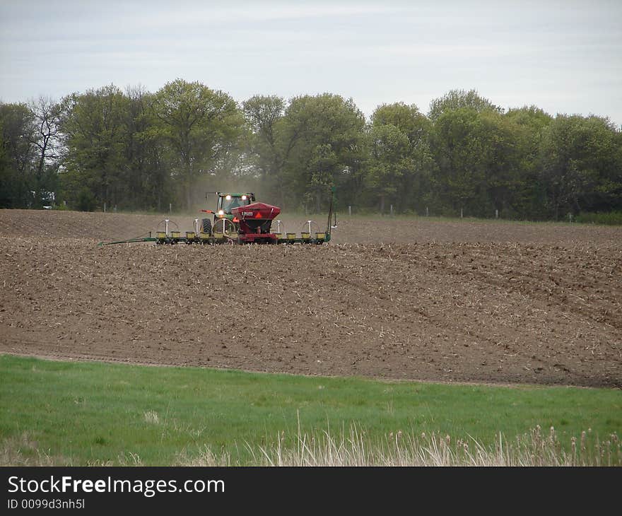 A farmer tilling his fields with his tractor. A farmer tilling his fields with his tractor.