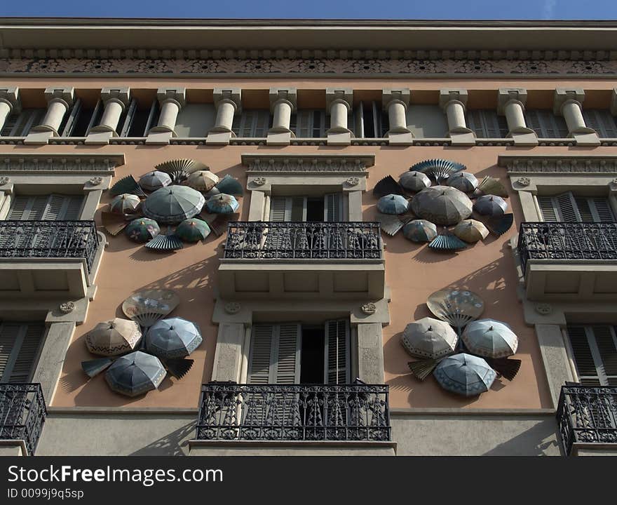 Facade of an old house decorated with umbrellas and fans. Facade of an old house decorated with umbrellas and fans