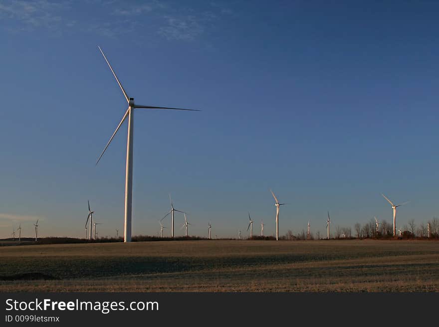 A group of wind turbines in the early morning light. A group of wind turbines in the early morning light.