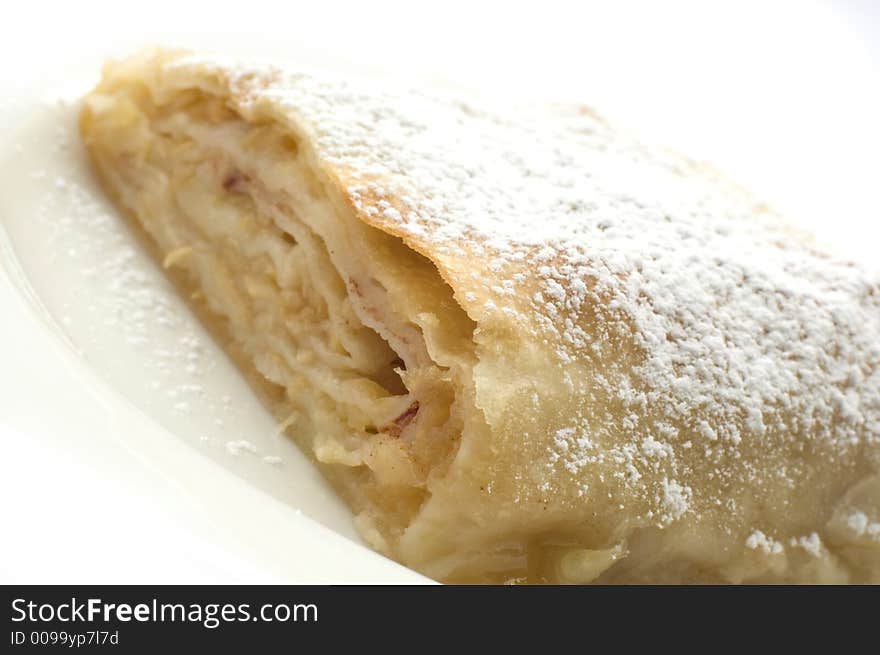 Sweet apple pie on white plate close up