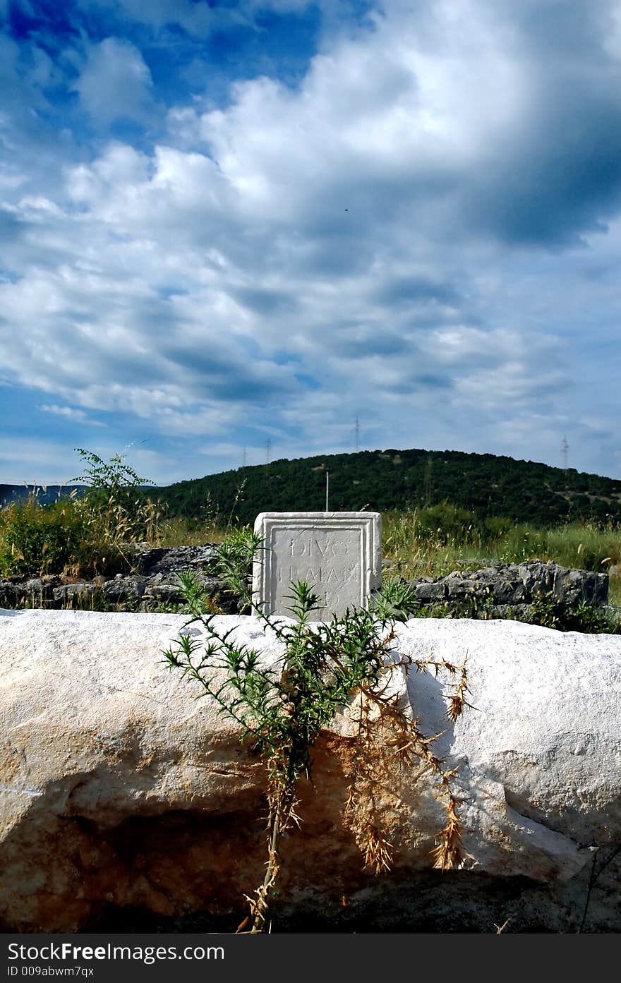 Remains of old roman abutment and epitaph with before storm clouds. Remains of old roman abutment and epitaph with before storm clouds.