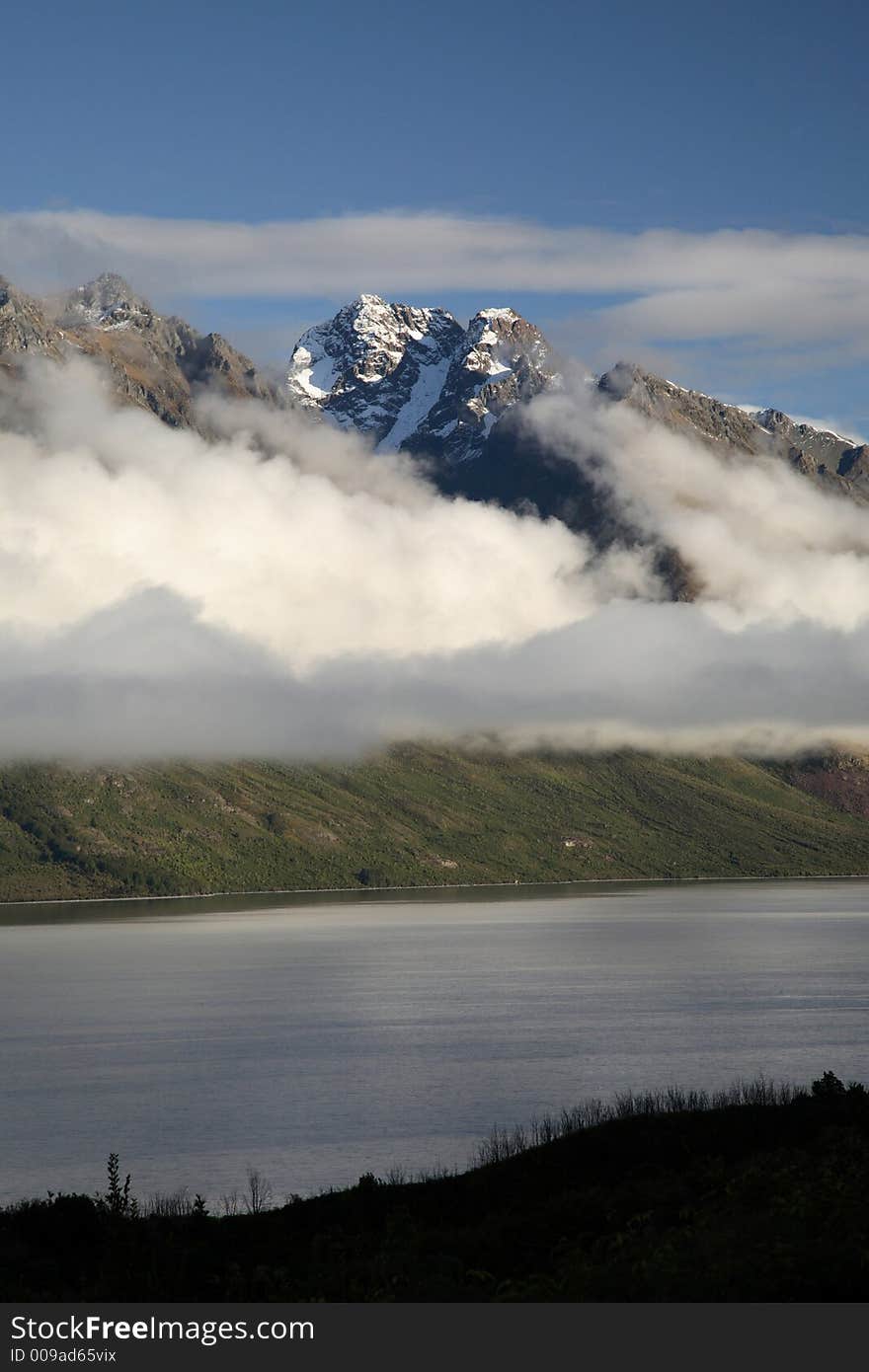 Cloudy mountain with snow on top and lake at New Zealand. Cloudy mountain with snow on top and lake at New Zealand