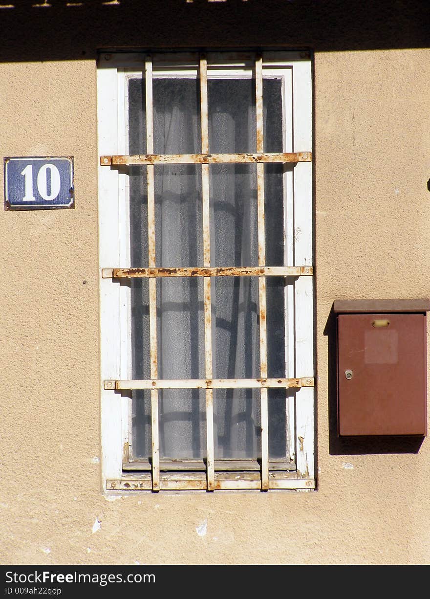 Old window with rusty fretwork and home number 10. Old window with rusty fretwork and home number 10