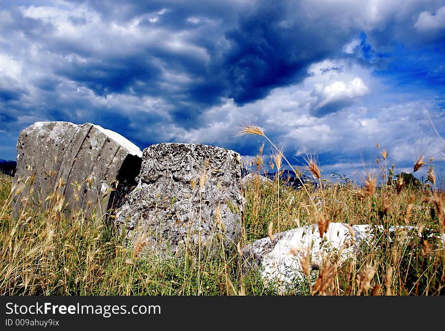 Remains of old roman abutment and epitaph with before storm clouds. Remains of old roman abutment and epitaph with before storm clouds.