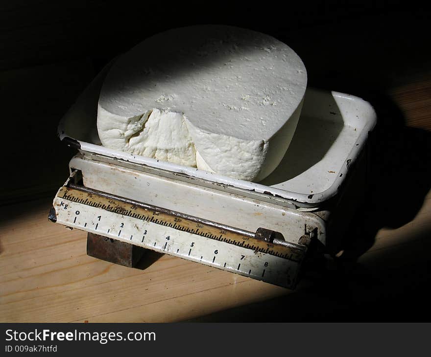 Big piece of cottage cheese cut off for a buyer and weighed on old scales. Big piece of cottage cheese cut off for a buyer and weighed on old scales.