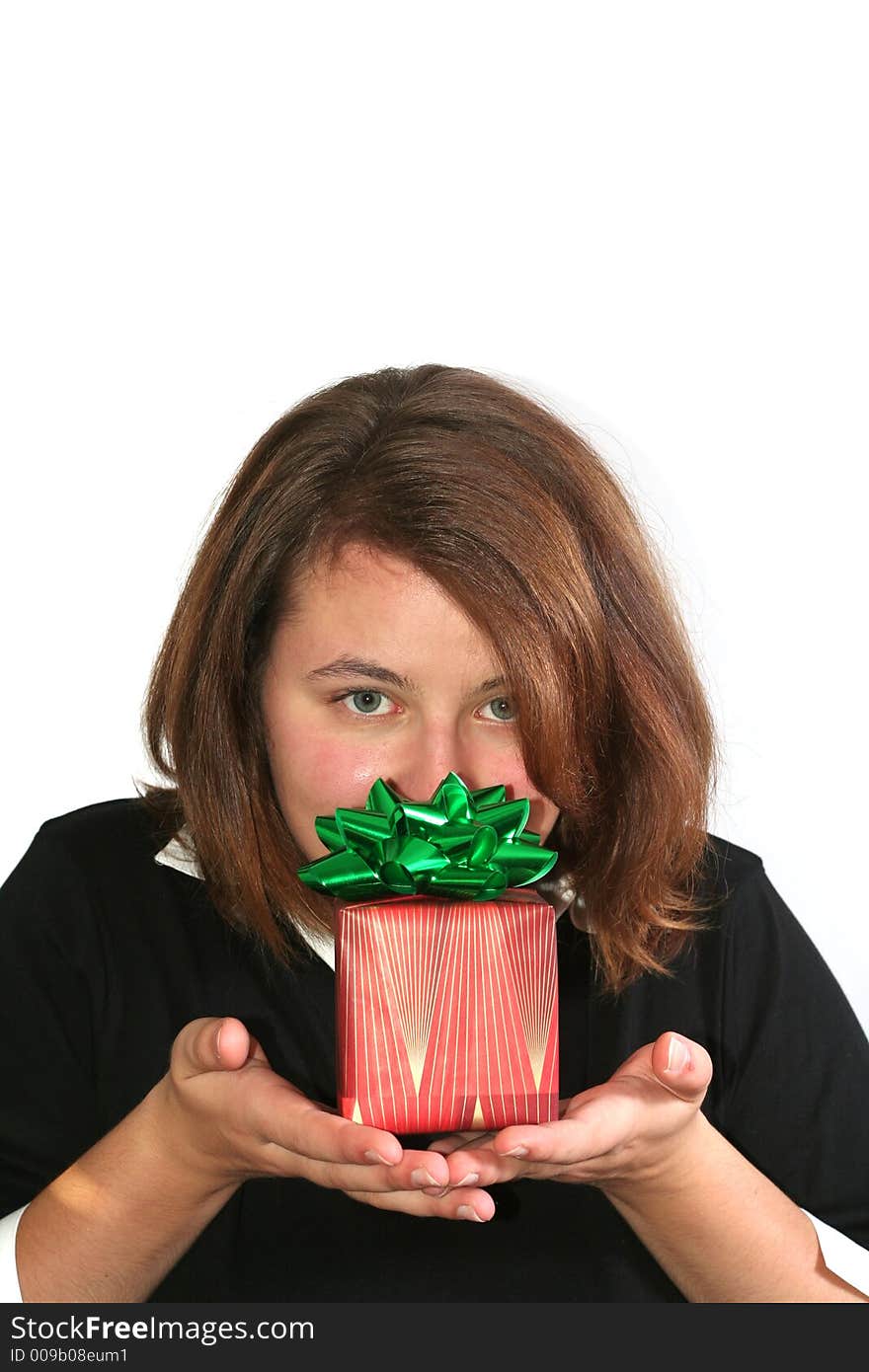 Beautiful girl holding up a wrapped gift: Christmas or other holiday concept. Beautiful girl holding up a wrapped gift: Christmas or other holiday concept