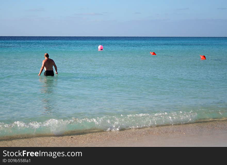 Man on the tropical beach going into the water. Man on the tropical beach going into the water