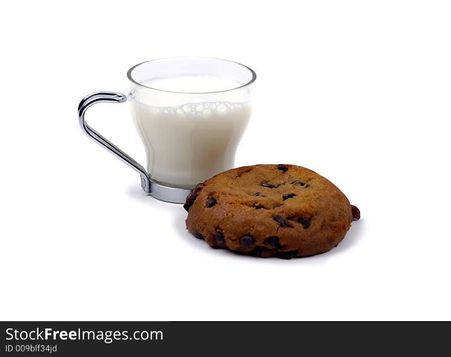 A pumpkin cookie isolated against a white background with a small glass of milk. A pumpkin cookie isolated against a white background with a small glass of milk.