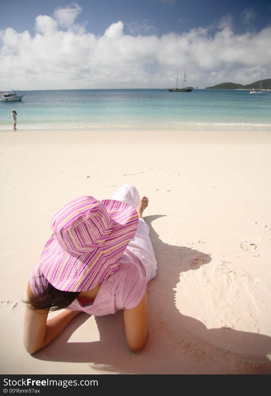 A woman relaxing on the beach at Whitsunday island, Australia. A woman relaxing on the beach at Whitsunday island, Australia