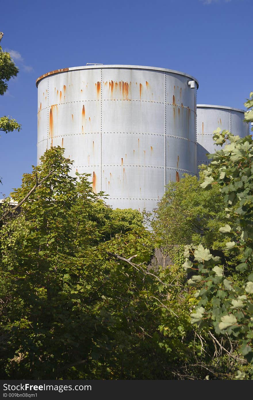 Rust marks on a grey industrial tank against a blue sky. Rust marks on a grey industrial tank against a blue sky