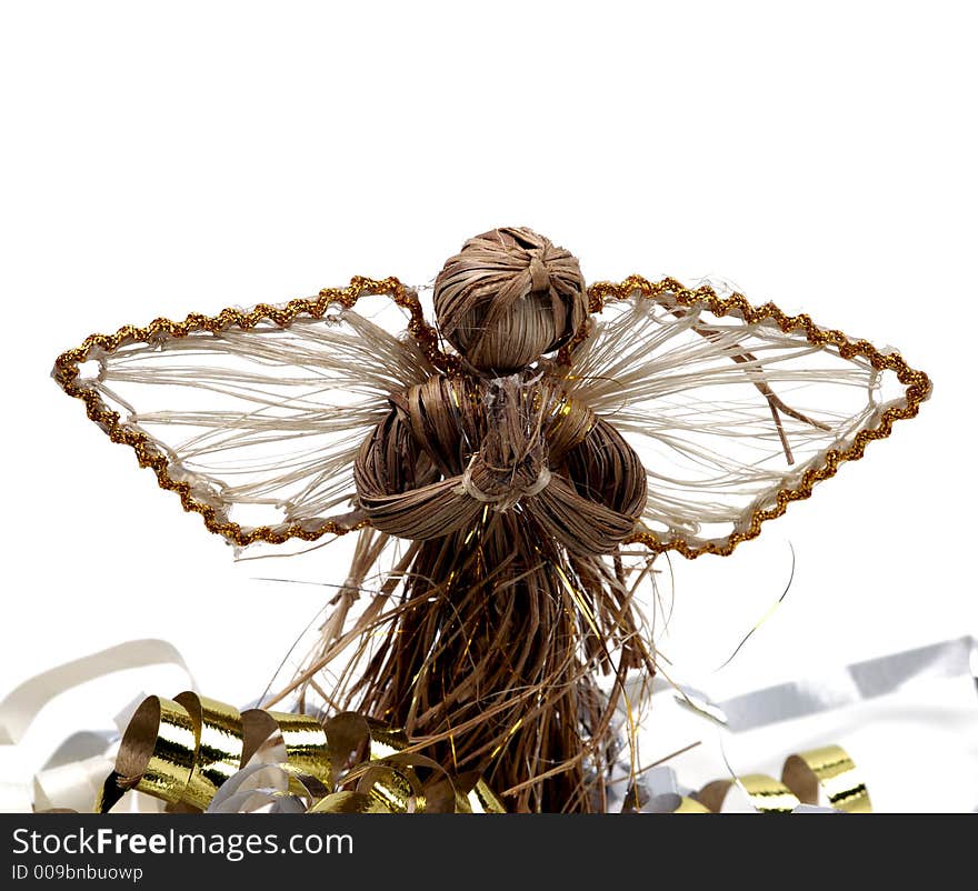 A rustic angel decoration amid colorful streamers and isolated against a white background. A rustic angel decoration amid colorful streamers and isolated against a white background.