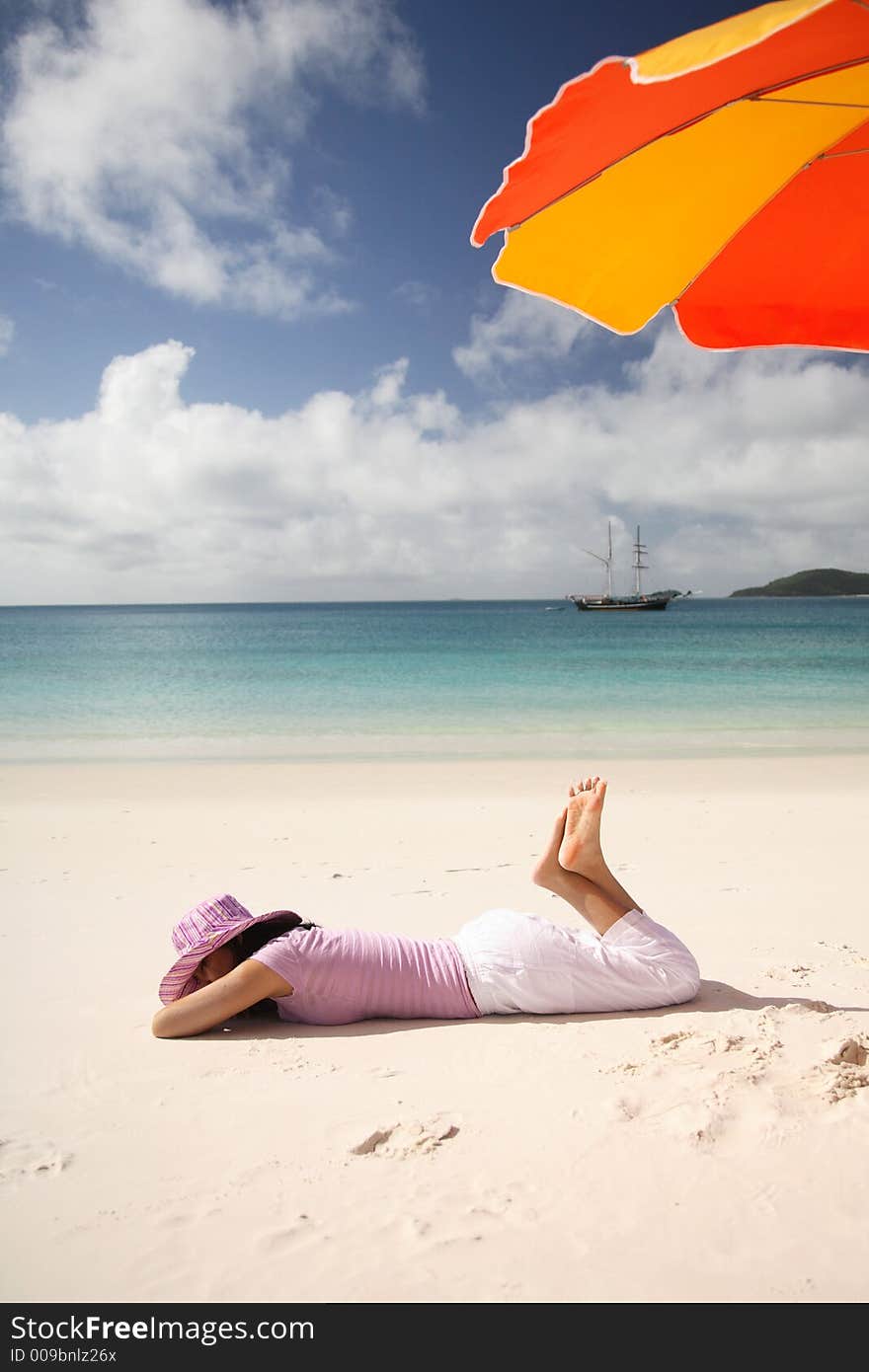 A woman relaxing on the beach at Whitsunday island, Australia. A woman relaxing on the beach at Whitsunday island, Australia