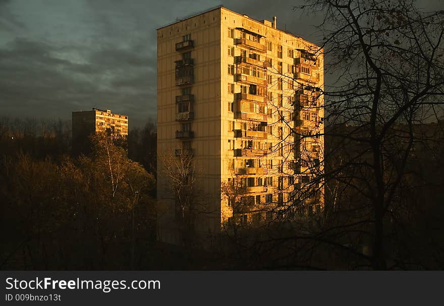 The sun on a dawn, shines on a panel high-rise building in suburb. The sun on a dawn, shines on a panel high-rise building in suburb