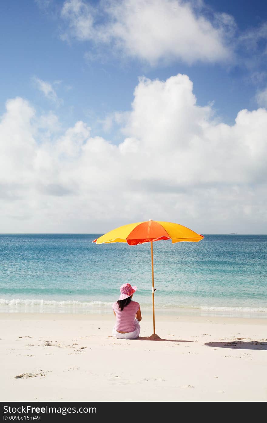 A woman relaxing on the beach at Whitsunday island, Australia. A woman relaxing on the beach at Whitsunday island, Australia