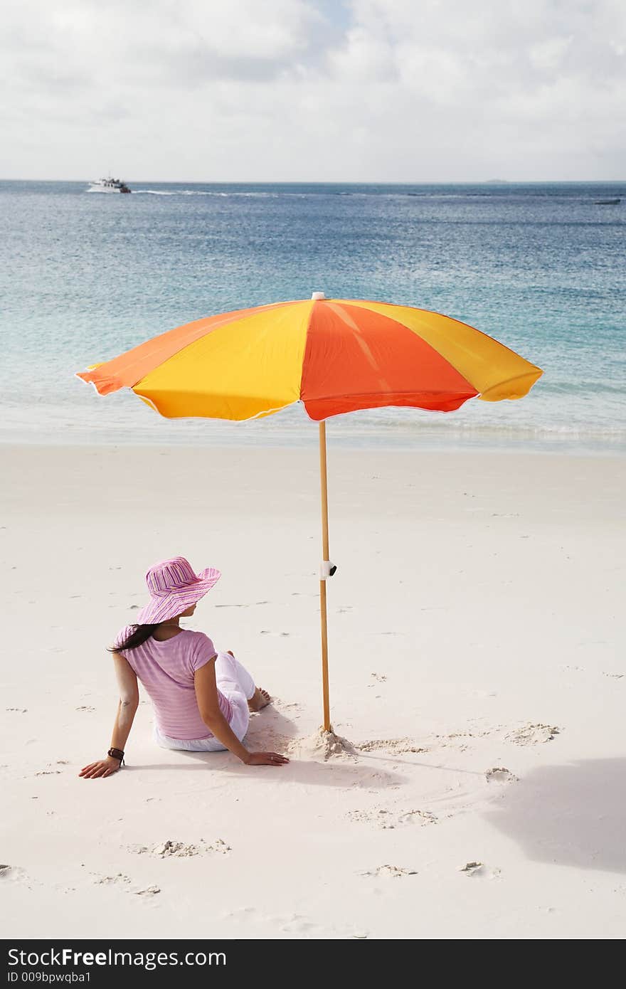 A woman relaxing on the beach in Whitsunday island; Australia. A woman relaxing on the beach in Whitsunday island; Australia