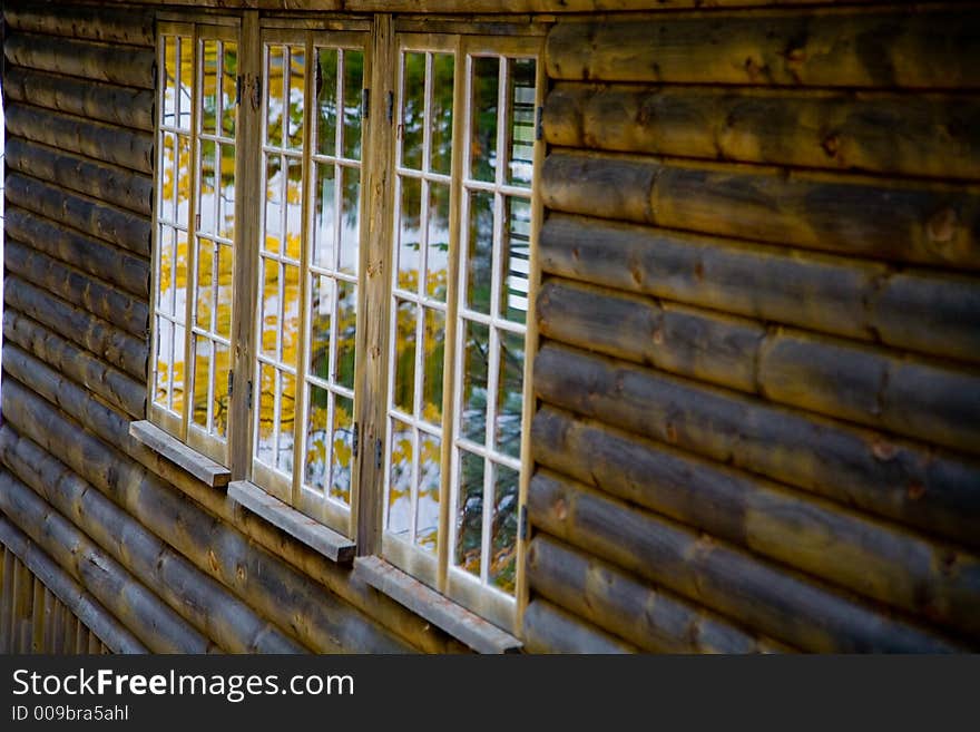 Fall Foliage reflected in Window of Log Home in Rural New England