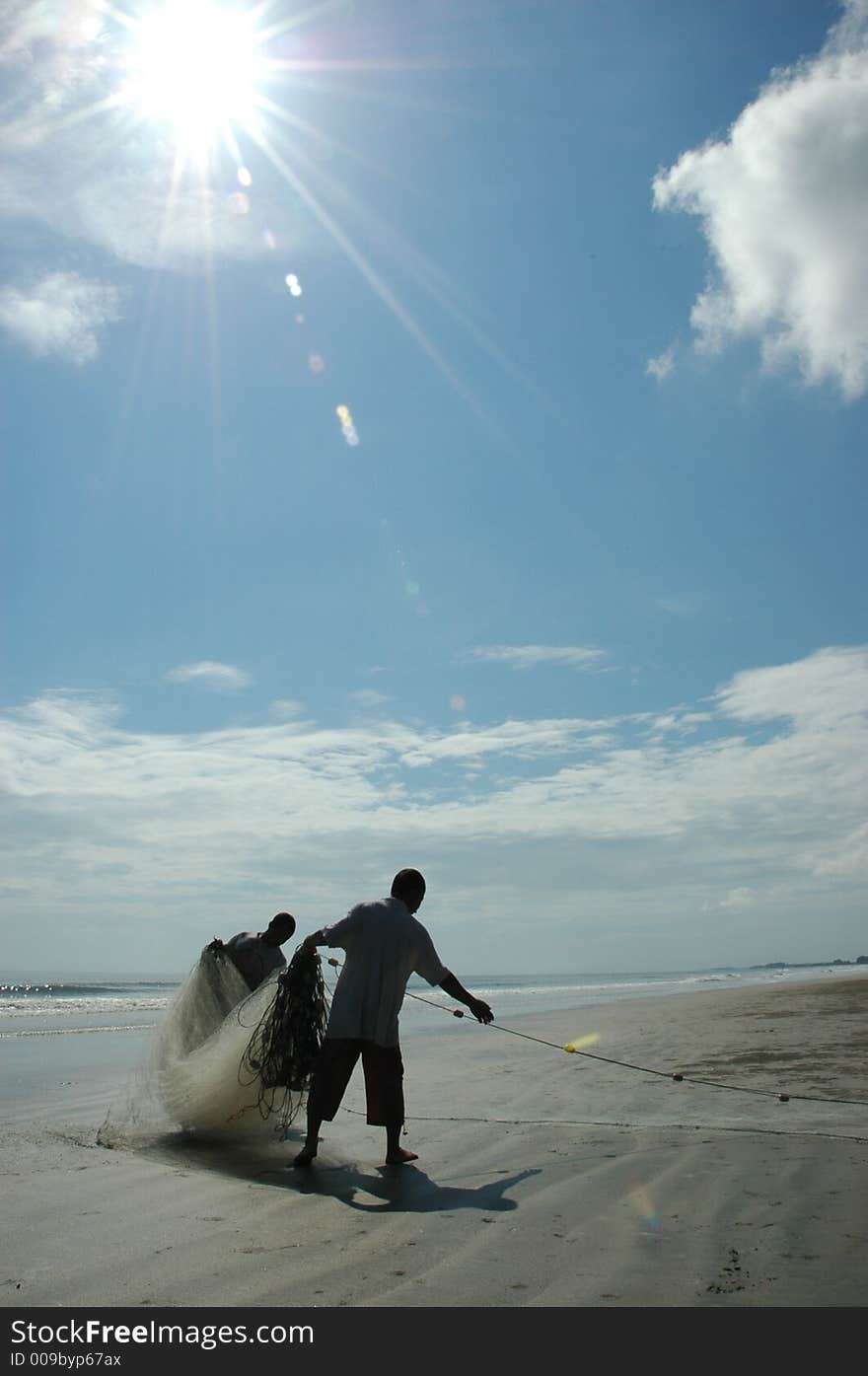 Fisherman organising their fishing net at Pantai Sepat under the sun. Fisherman organising their fishing net at Pantai Sepat under the sun.