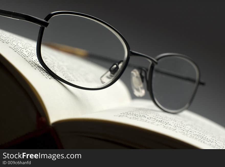 Dark glasses on a book close up