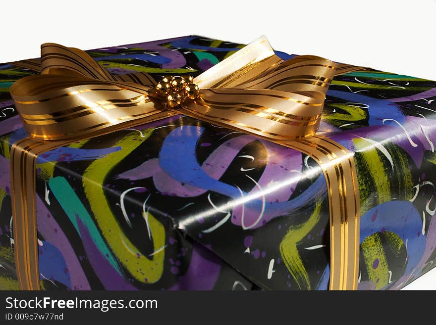 Present wrapped in colourful paper and tied with a golden ribbon. Present wrapped in colourful paper and tied with a golden ribbon