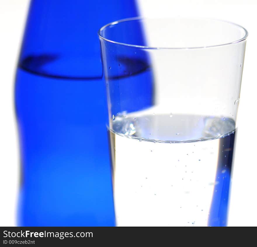 Glass of Mineral Water and Blue Bottle. Shallow DOF. Glass of Mineral Water and Blue Bottle. Shallow DOF.