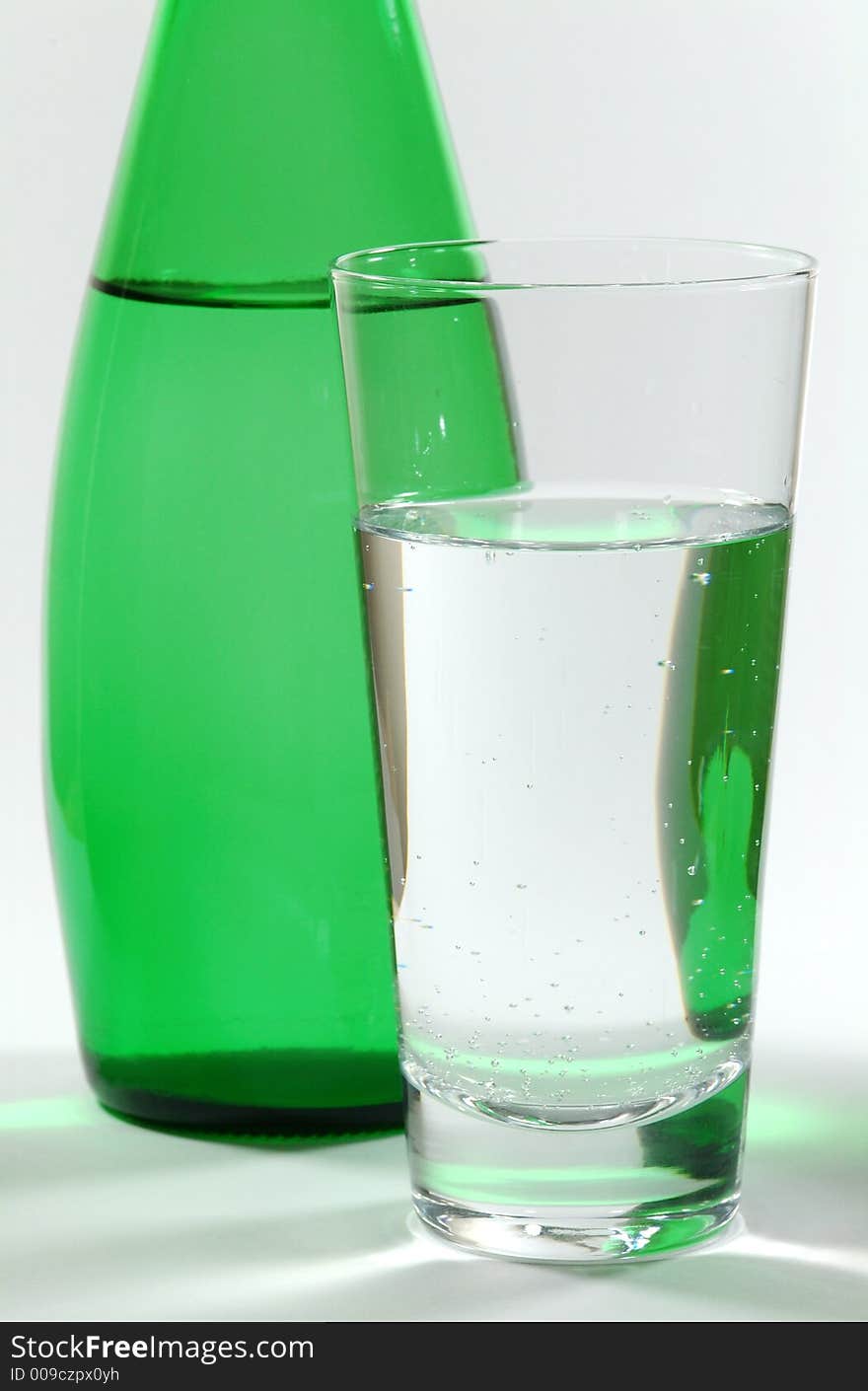 Glass of Mineral Water and Green Bottle. Glass of Mineral Water and Green Bottle