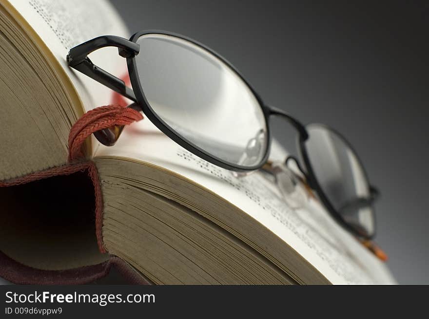 Dark glasses on a book close up