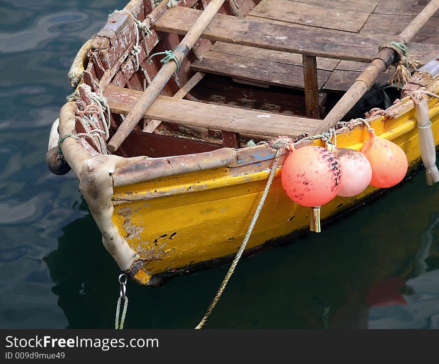 Old yellow fishing oar boat with three mooring buoys. Old yellow fishing oar boat with three mooring buoys.