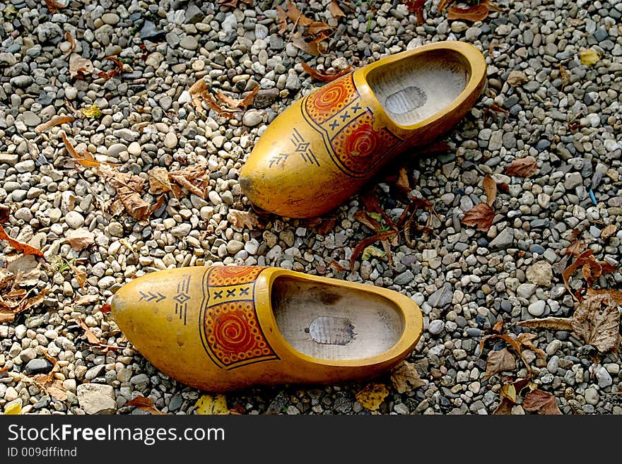 Wooden shoes are left in the gravel. Wooden shoes are left in the gravel.