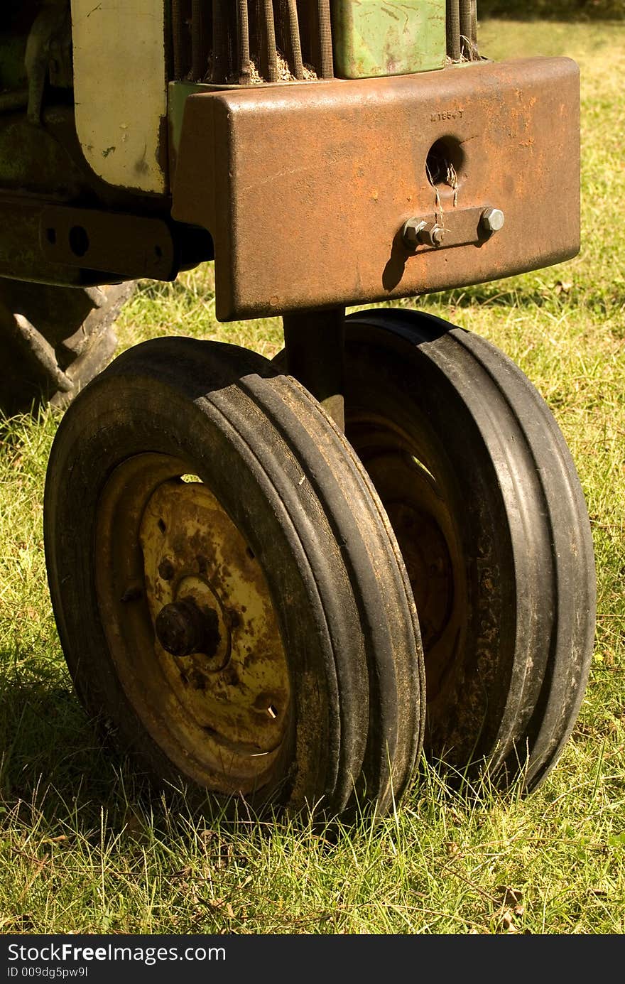 Closeup of two front tractor wheels on a very old, antique tractor. Closeup of two front tractor wheels on a very old, antique tractor.